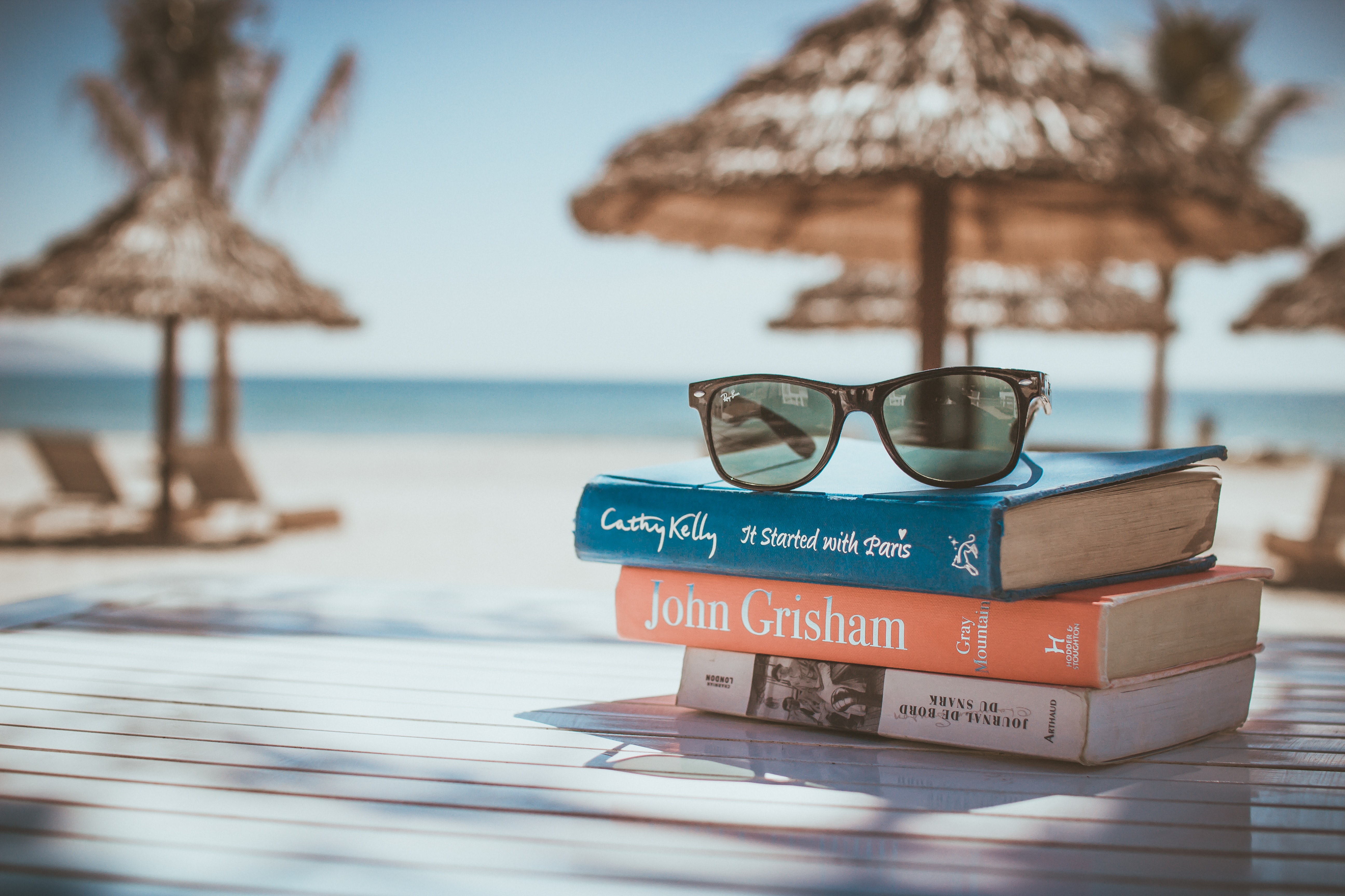 Sunglasses on a book stack | Turning Vacay Dreams Into A Reality | Backpacking with Bacon